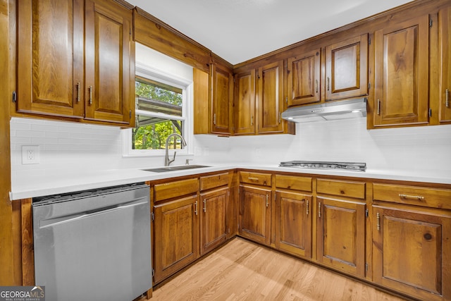 kitchen featuring sink, light hardwood / wood-style flooring, stainless steel appliances, and backsplash