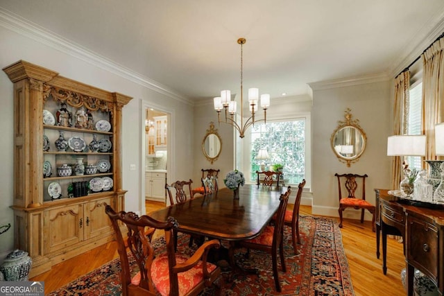 dining area featuring an inviting chandelier, ornamental molding, and light hardwood / wood-style flooring