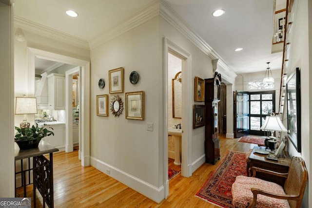 hallway featuring ornamental molding and light hardwood / wood-style flooring