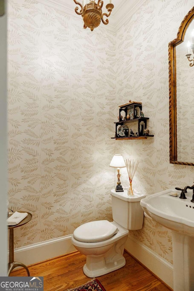 bathroom with ornamental molding, hardwood / wood-style floors, and toilet