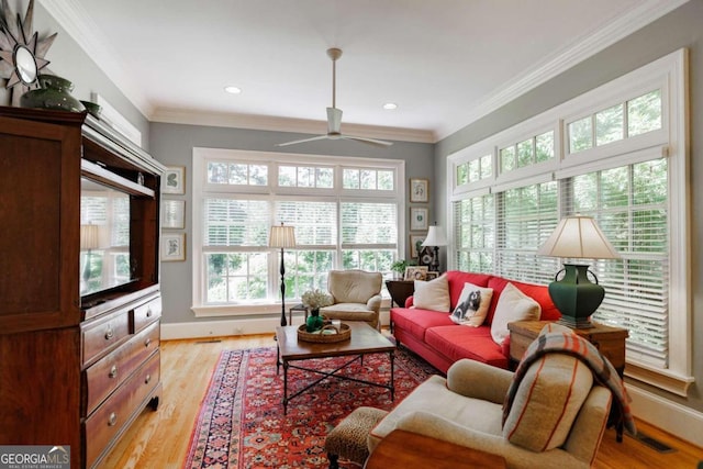 living room with ceiling fan, crown molding, and light hardwood / wood-style floors