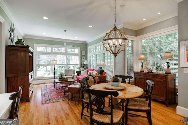 dining room with light hardwood / wood-style floors, a chandelier, and ornamental molding