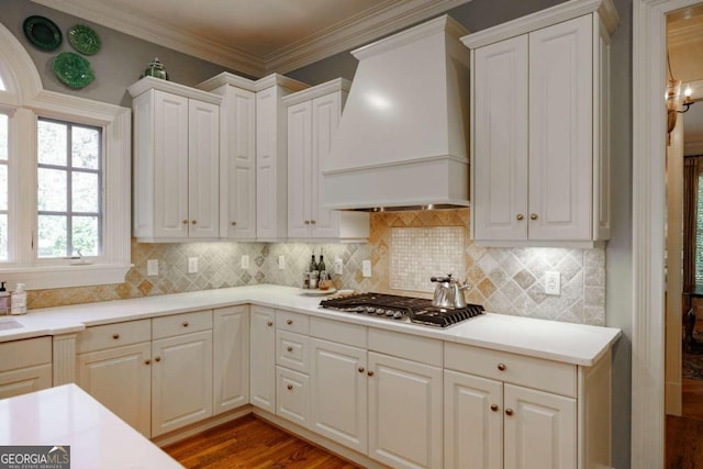 kitchen with custom exhaust hood, dark hardwood / wood-style floors, stainless steel gas cooktop, and white cabinets