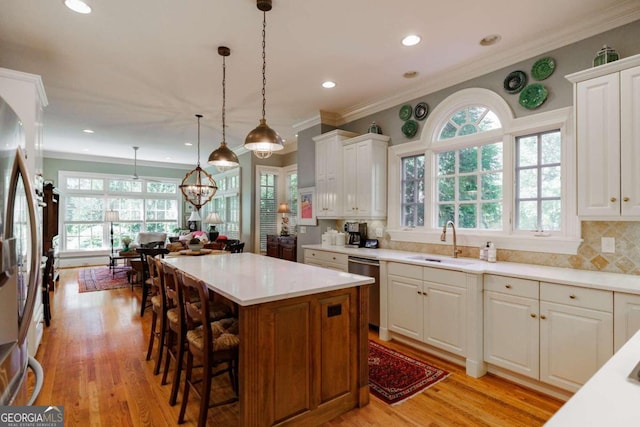 kitchen featuring light hardwood / wood-style flooring, white cabinets, sink, and a center island