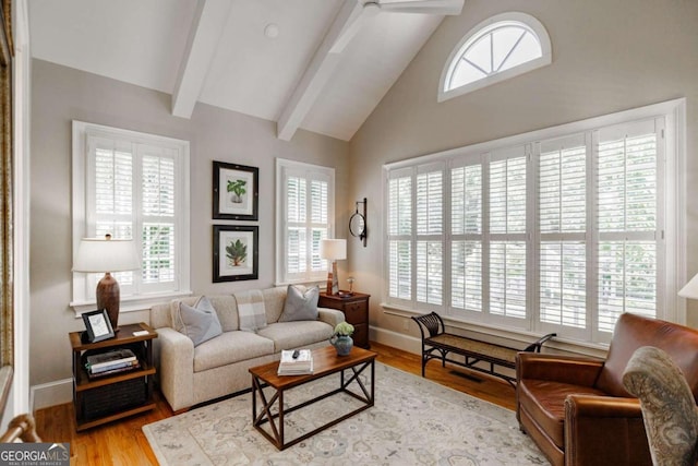 living room with light wood-type flooring, high vaulted ceiling, and beam ceiling