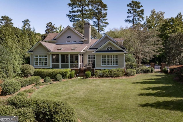 back of property with a yard and a sunroom