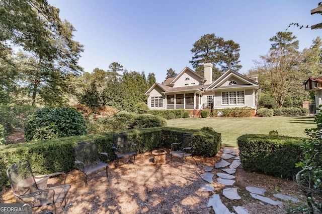 view of front of house featuring a sunroom and a front yard