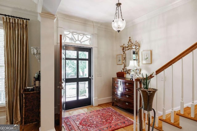 foyer entrance featuring ornamental molding, a notable chandelier, and wood-type flooring