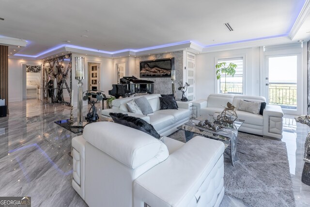 living area featuring a raised ceiling, marble finish floor, and ornamental molding