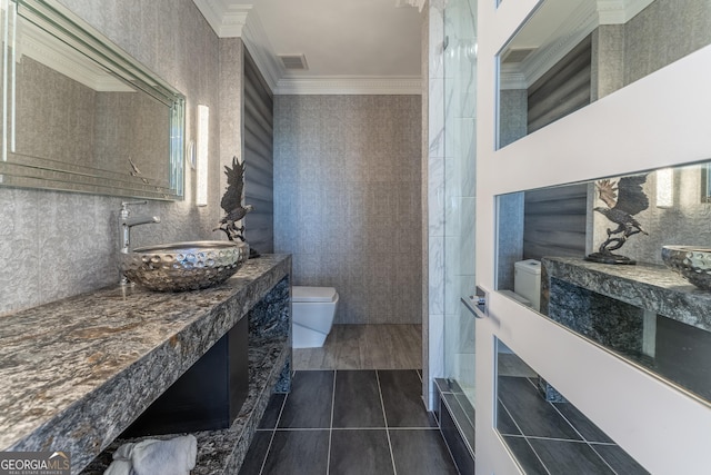 full bathroom with visible vents, crown molding, toilet, vanity, and tile walls