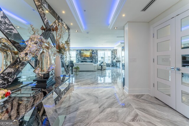 entrance foyer featuring french doors, marble finish floor, and ornamental molding