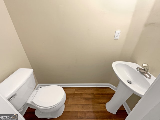 bathroom featuring wood-type flooring and toilet