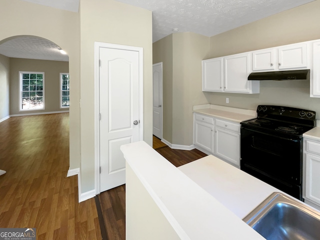 kitchen featuring black range with electric stovetop, a textured ceiling, dark wood-type flooring, and white cabinetry