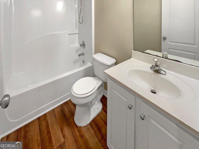 full bathroom featuring hardwood / wood-style flooring, tub / shower combination, toilet, and vanity