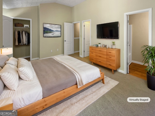 carpeted bedroom with a closet and lofted ceiling