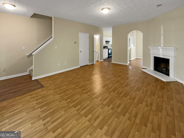 unfurnished living room with hardwood / wood-style flooring and a textured ceiling