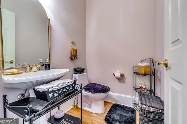 bathroom with sink, toilet, and wood-type flooring