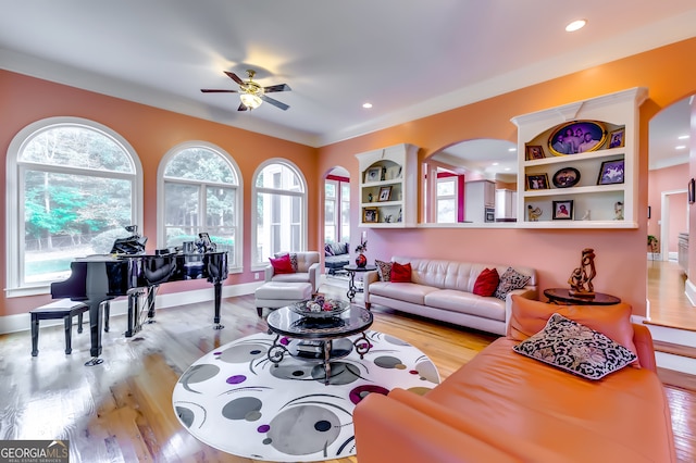 living room with ceiling fan, a wealth of natural light, and light hardwood / wood-style flooring