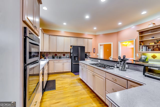 kitchen featuring stainless steel appliances, backsplash, and light hardwood / wood-style flooring