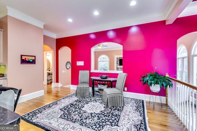 interior space with wood-type flooring, ornamental molding, and ceiling fan