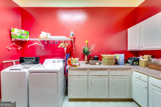 clothes washing area featuring cabinets and washing machine and dryer