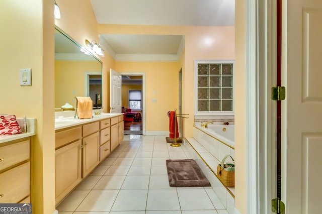 bathroom featuring a relaxing tiled tub, tile patterned flooring, and vanity