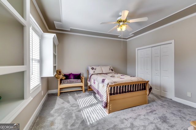 bedroom featuring multiple windows, ceiling fan, a closet, and light colored carpet