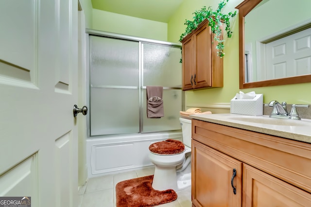 full bathroom featuring enclosed tub / shower combo, vanity, tile patterned flooring, and toilet