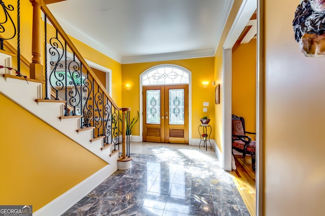 foyer entrance with ornamental molding, hardwood / wood-style flooring, and french doors