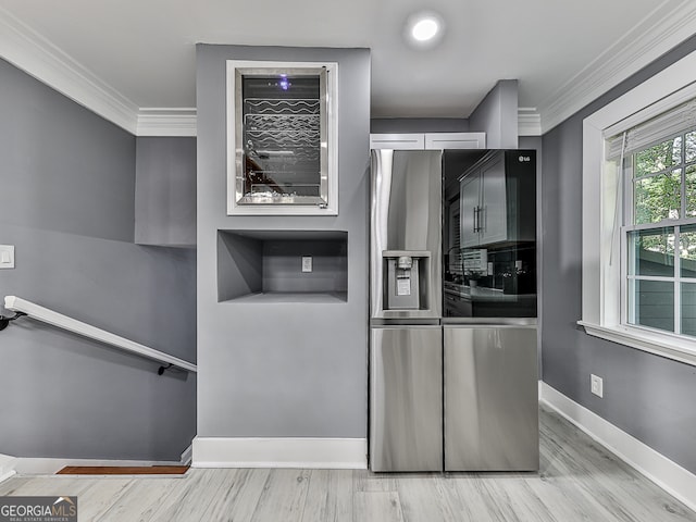 kitchen with light hardwood / wood-style floors, crown molding, and stainless steel fridge with ice dispenser