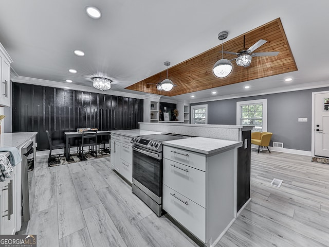 kitchen with light hardwood / wood-style floors, decorative light fixtures, appliances with stainless steel finishes, a center island, and white cabinetry