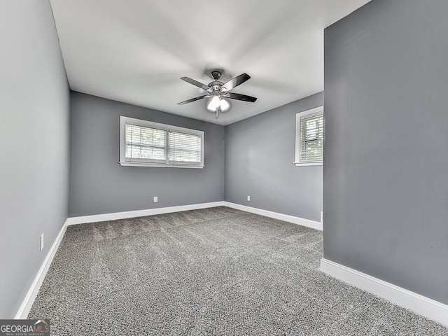 carpeted empty room featuring ceiling fan and a wealth of natural light