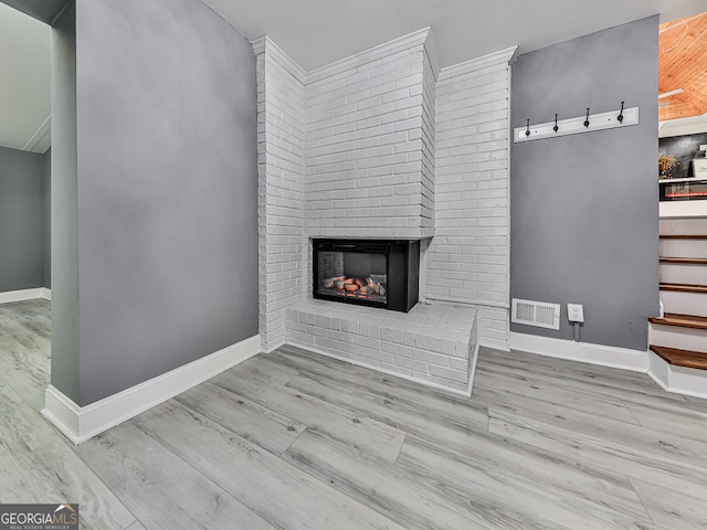 unfurnished living room with a fireplace and light hardwood / wood-style floors