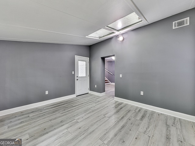 spare room with lofted ceiling and light hardwood / wood-style floors