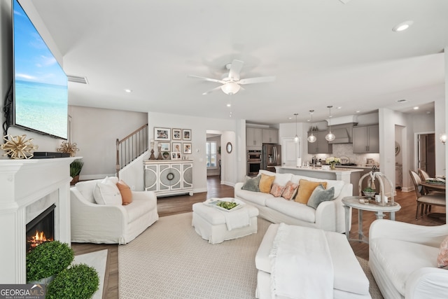 living room featuring ceiling fan and light hardwood / wood-style flooring