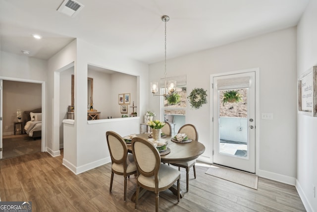 dining space with an inviting chandelier and hardwood / wood-style floors