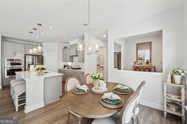 dining space with hardwood / wood-style flooring and a chandelier