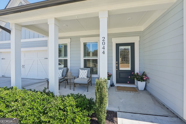 entrance to property featuring covered porch and a garage