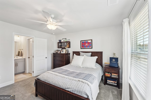 bedroom with ceiling fan, light carpet, and ensuite bath