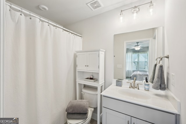 bathroom with vanity, toilet, and ceiling fan