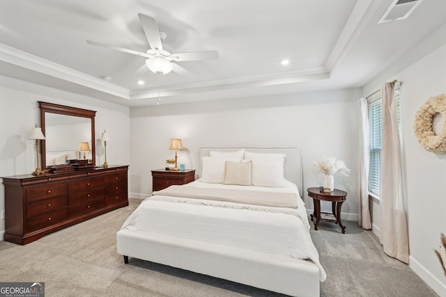 carpeted bedroom with a raised ceiling and ceiling fan