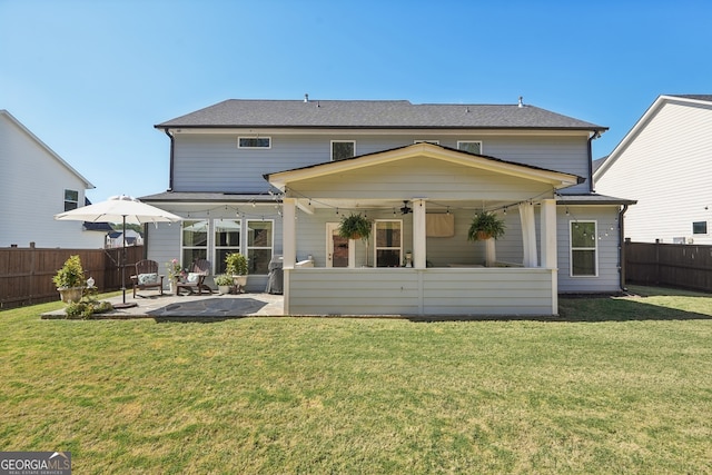 rear view of house featuring a patio area, a lawn, and ceiling fan