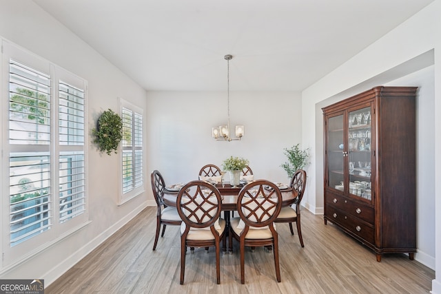 dining area featuring light hardwood / wood-style floors and a notable chandelier