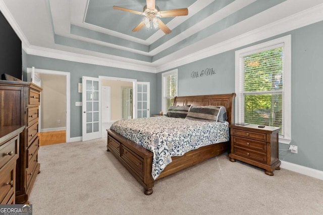 carpeted bedroom featuring crown molding, french doors, ceiling fan, and a raised ceiling