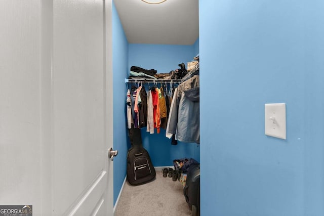 walk in closet featuring light colored carpet