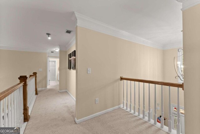 hallway featuring an inviting chandelier, light colored carpet, and crown molding