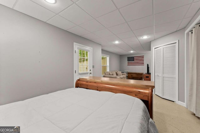 bedroom with a paneled ceiling and a closet