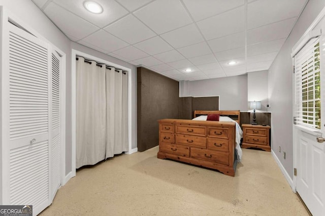 bedroom featuring a drop ceiling and a closet