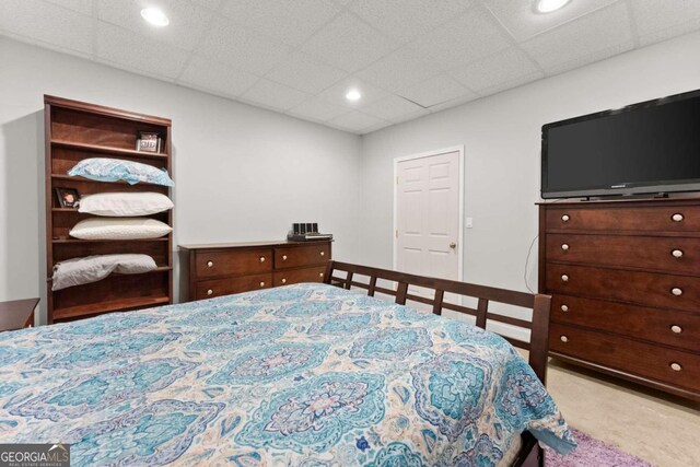 unfurnished bedroom featuring a paneled ceiling and light carpet