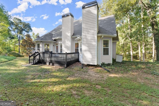 rear view of property with a deck and a yard